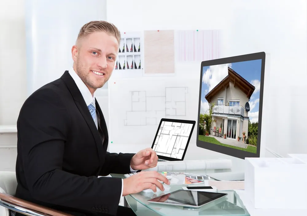 Real estate virtual assistant at his desk with a house listing on screen
